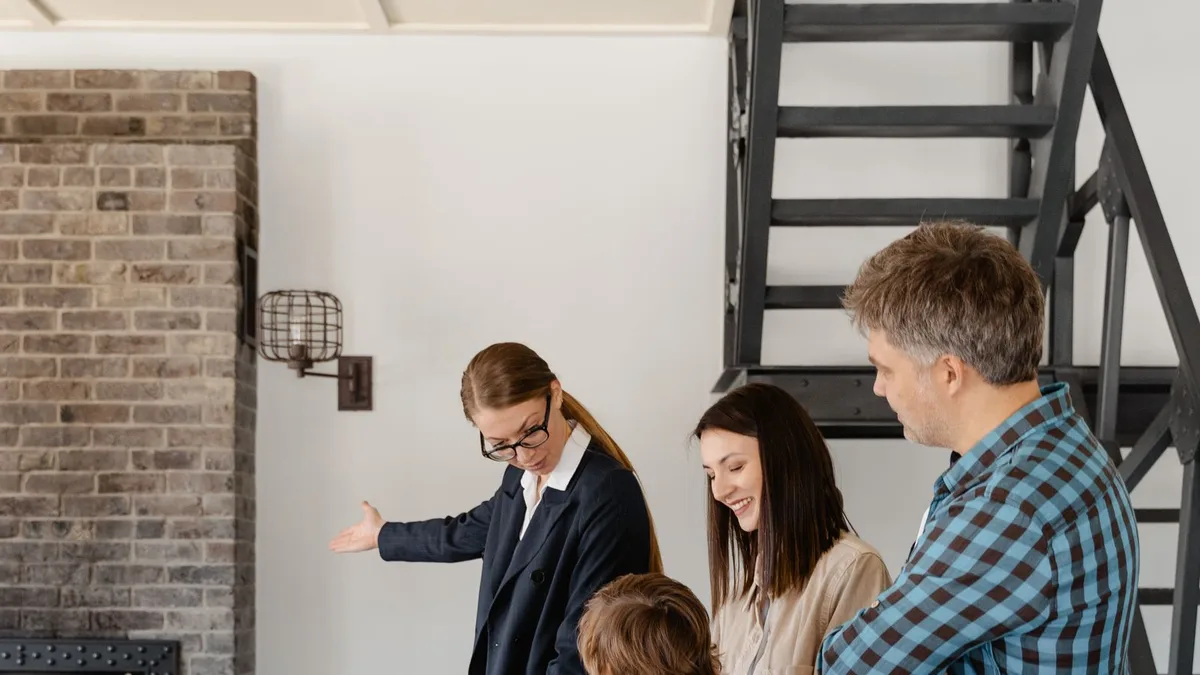 A real estate agent showing a property to two clients inside a home