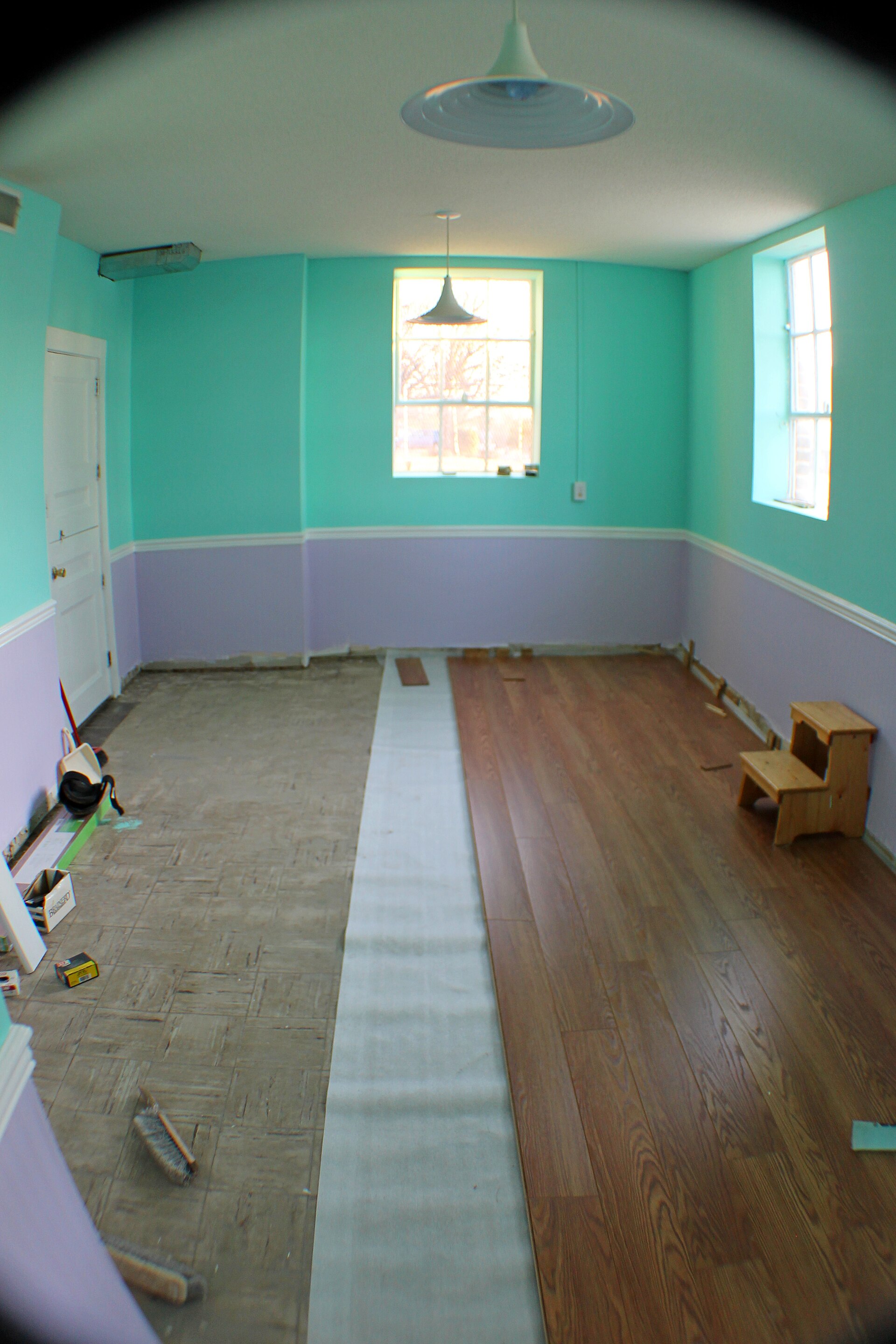 Real laminate planks being laid, showing the actual texture and finish of a floor