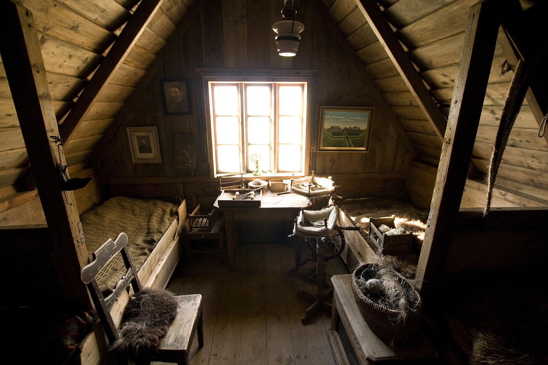 A raw unconverted attic with timber rafters and a single window