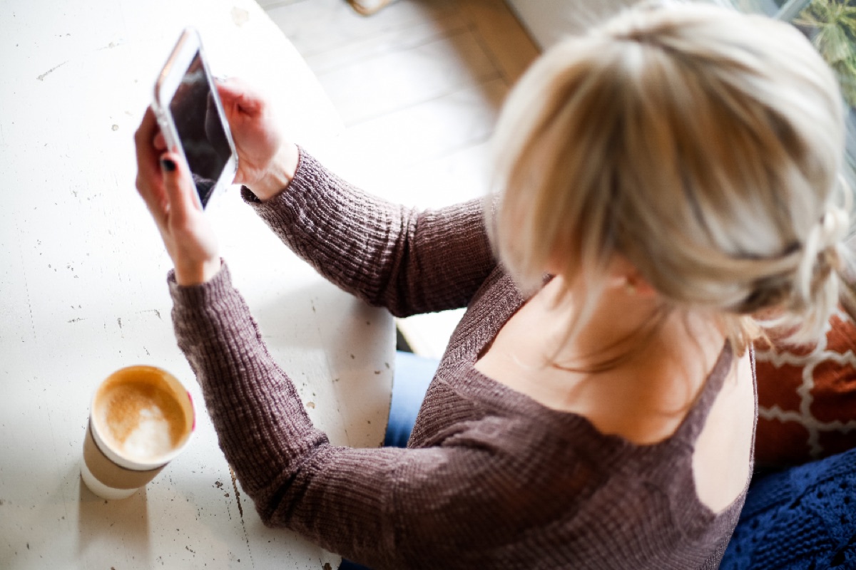 A hand holding a smartphone, sending a customer message